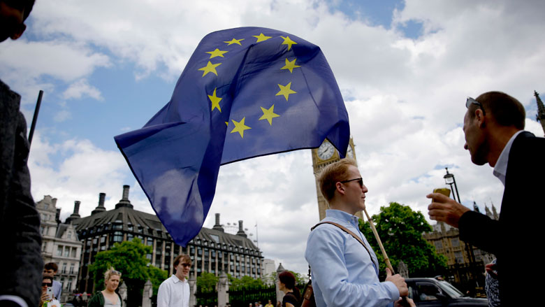In this Friday, June 24, 2016 file photo, a remain supporter stops to talk to people as he walks around with his European flag across the street from the Houses of Parliament in London. (AP Photo/Matt Dunham, File)